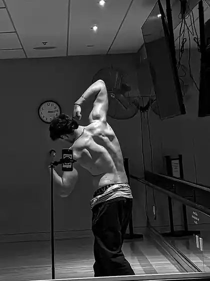 Me at 210 lb today, back pose in the gym mirror